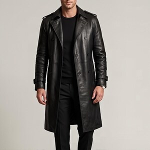 Pode incluir: Um trench coat de couro preto com design de abotoamento duplo. O casaco apresenta gola entalhada, ombreiras e detalhe de cinto nos punhos. O casaco é comprido até ao joelho e tem um corte clássico e sob medida.