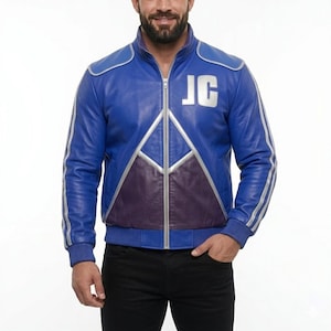 Puede incluir: Chaqueta de cuero azul con detalles plateados y las iniciales "JC". La chaqueta presenta un panel morado, rayas plateadas en las mangas, cierre de cremallera y puños y dobladillo acanalados. Prenda de vestir exterior elegante.
