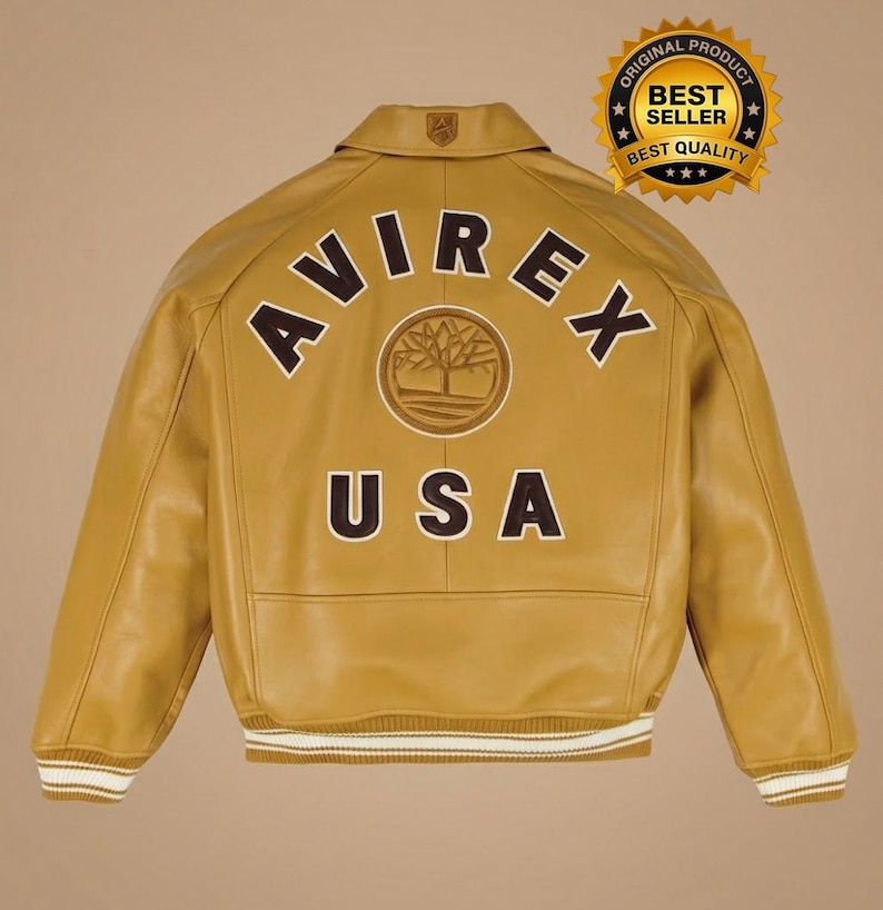 May include: Mustard yellow leather jacket with the text "AVIREX USA" on the back. The jacket has a collar, a logo on the upper back, and white and brown striped cuffs and hem. A gold seal reads "ORIGINAL PRODUCT BEST SELLER BEST QUALITY".