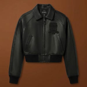 Puede incluir: Chaqueta bomber de cuero negro con cremallera, cuello y pu&ntilde;os y dobladillo de canal&eacute;. Cuenta con un parche en el pecho y la marca "AVIREX" en el cuello.