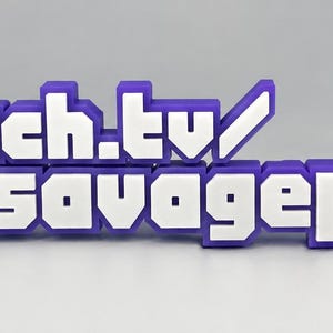 Könnte beinhalten: Ein 3D-gedrucktes Schild mit dem Text twitch.tv/og_savagepotato in einer blockartigen, verpixelten Schriftart. Die Buchstaben sind weiß mit einem dicken violetten Rand, und das Twitch-Logo befindet sich links neben dem Text.