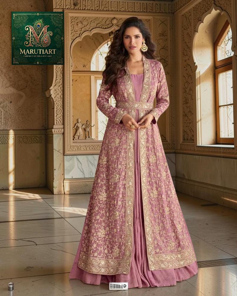 May include: A mauve-coloured gown with gold embroidery and a matching long jacket. The jacket has gold trim and a cinched waist. The image includes the Marutitart logo in the upper left corner.