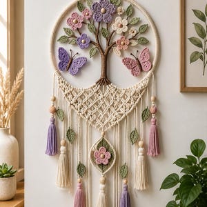 May include: A circular macrame wall hanging featuring a central brown tree with crocheted purple, pink, and white flowers and green leaves. Two crocheted butterflies in purple and pink flank the tree. The base has intricate knots, wooden beads, and tassels.