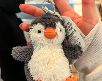 Pingente de pinguim Jellycat macio e fofinho em formato de amendoim. Uma ótima opção para presente. Acompanha saquinho de proteção e etiqueta.