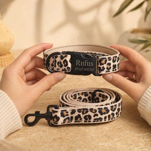 Op de afbeelding: Een halsband en bijpassende riem voor huisdieren van beige stof met een zwart en bruin luipaardpatroon. De halsband heeft een zwarte plastic gesp gegraveerd met de naam Rufus en het nummer 07123 456789, plus een zwarte metalen D-ring.