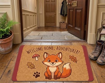 Könnte beinhalten: Eine rechteckige Fußmatte mit beiger, strukturierter Oberfläche und dunkelrotem Rand. Sie zeigt einen Cartoon-Fuchs, einen Pilz, zwei Eichenblätter und einen Pfotenabdruck. Der Text "WELCOME HOME, ADVENTURER!" ist in dunkelbraunen Buchstaben gedruckt.