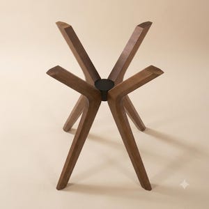 May include: A furniture base featuring five angled wooden legs connected to a central black circular hub. The legs are made of a medium-toned wood with a visible grain, extending outward and downward to provide a stable foundation for a table top.