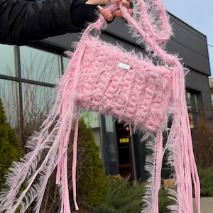 Könnte beinhalten: Ein Set aus drei Keramikbechern mit gesprenkelter, matter Oberfläche. Die Becher sind in Creme-, Hellgrau- und Dunkelgrautönen gehalten. Jeder Becher hat ein schlichtes, minimalistisches Design und einen abgerundeten Henkel.