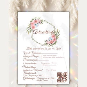 May include: A white RSVP card featuring a floral wreath with pink and blue flowers surrounding a gold geometric hexagon. The text includes 'Antwortkarte', 'Bitte antwortet uns bis zum 14. April', and various German event fields, plus a QR code.