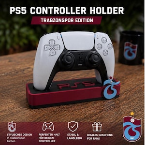 Op de afbeelding: Een witte en zwarte PS5-controller op een bordeauxrode basis met de tekst "PS5" en een blauw-wit logo. De tekst "PS5 CONTROLLER HOLDER" en "TRABZONSPOR EDITION" staan bovenaan.