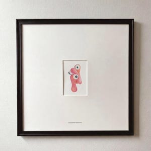 May include: A set of three ceramic mugs with a speckled, cream-colored glaze. Each mug features a different hand-painted design: a blue and green leaf, a yellow flower, and a red berry. The mugs have a simple, rounded shape.