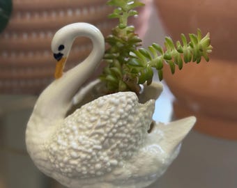 Maceta pequeña con forma de cisne, pintada a mano y firmada KAF 90 en la base.