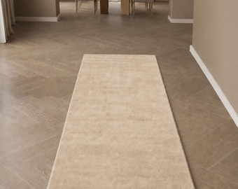 Alfombra de pasillo minimalista de lana de Nueva Zelanda tejida a mano, color beige neutro suave.