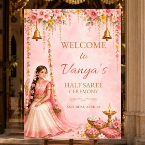 May include: A rectangular welcome sign for a half saree ceremony featuring a pink watercolor background, floral garlands, hanging brass bells, and an illustration of a person in traditional attire sitting on a swing, with the text Vanya's Half Saree Ceremony.