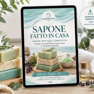 Può includere: Un tablet digitale che mostra una guida intitolata SAPONE FATTO IN CASA, con testo su ricette ed etichette per sapone fatto in casa. Lo schermo mostra una pila di tre saponette rettangolari, rametti di lavanda e una ciotola di sali da bagno.