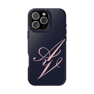May include: A dark navy blue smartphone case featuring a light pink calligraphic monogram of the letters A and V centred on the back. The case includes a cutout for a triple-lens camera system located in the upper left corner of the device.