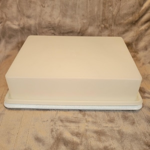 Puede incluir: Un recipiente cuadrado de plástico blanquecino con tapa a juego. La base tiene un patrón moteado gris claro. La tapa encaja a ras en la base. Diseñado para el almacenamiento de alimentos.