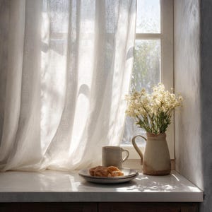 May include: A sunlit interior scene featuring a window with sheer white curtains. A ceramic mug and plate with pastries sit on a countertop, next to a vase of white flowers. The scene evokes a sense of calm and tranquility.