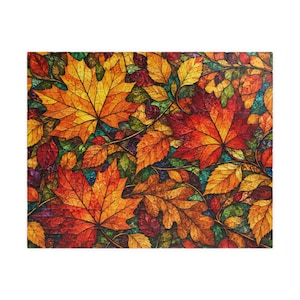 May include: A rectangular jigsaw puzzle featuring a dense, vibrant pattern of autumn leaves in shades of orange, red, yellow, and brown. The design mimics a stained glass aesthetic with dark outlines separating each leaf and foliage element.