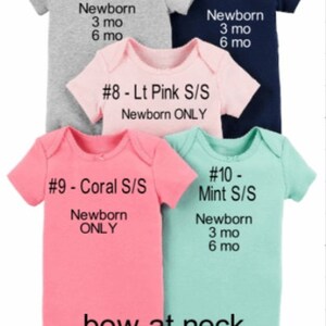 May include: Five baby onesies in different colours and sizes. The onesies are labelled with numbers and colours, including grey, navy, light pink, coral, and mint. The onesies are all short-sleeved and have a bow at the neck. The sizes are newborn, 3 months, and 6 months.