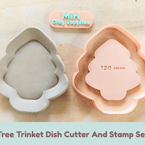 May include: A tree-shaped trinket dish cutter and stamp set. The cutter is light gray, and the stamp is peach-colored with the text 130 mm embossed on it. A small peach-colored plaque with the text Miri Clay Supplies is included.