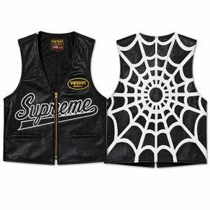 Pode incluir: Colete de couro preto com zíper dourado e a palavra "Supreme" em branco. A parte de trás do colete apresenta um design de teia de aranha branca. O colete tem dois bolsos pequenos e um patch "Vanson Leathers".
