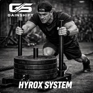 May include: Black and white image of a person pushing a weighted sled. The sled has several black weight plates. The text "HYROX SYSTEM" is at the bottom. The Gainshift logo is at the top left.