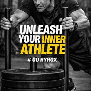 Może przedstawiać: Czarno-białe zdjęcie mężczyzny pchającego obciążone sanie. Tekst "UNLEASH YOUR INNER ATHLETE" jest wyświetlany w kolorze białym i ż&oacute;łtym. Widoczny jest r&oacute;wnież hashtag "# GO HYROX". Mężczyzna ma na sobie czapkę i odzież sportową.