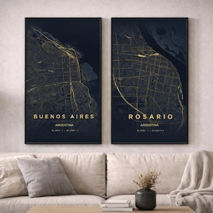 Puede incluir: Dos impresiones enmarcadas de mapas de ciudades de Buenos Aires y Rosario, Argentina, en oro sobre un fondo azul oscuro. Las impresiones se muestran encima de un sofá beige. El texto "Buenos Aires" y "Rosario" es dorado.