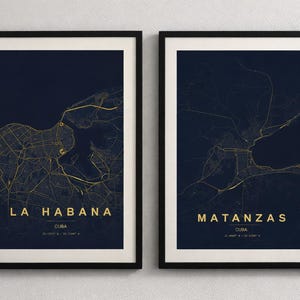 May include: Two framed prints with gold city maps on a dark blue backdrop. The left print reads "LA HABANA" and the right "MATANZAS", both in gold lettering. The prints are framed in black, suitable for home decor.