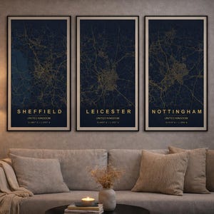 Puede incluir: Tres impresiones enmarcadas de mapas de las ciudades de Sheffield, Leicester y Nottingham, Reino Unido. Cada impresión presenta detalles dorados de calles y carreteras sobre un fondo azul oscuro. Los nombres de las ciudades son dorados.