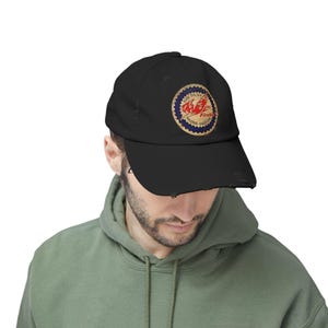 May include: Black distressed baseball cap with a circular patch featuring the text "Rase Oil Co. Fireb Racing Gasoline" and a red flame design. The cap has a curved brim and a worn appearance.