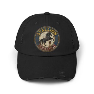 May include: Black baseball cap with a distressed design. The cap features a circular emblem with the word "STALLION" in a curved font, a rearing horse, and the words "RACING FREE". The cap has a curved brim and a distressed, worn look.