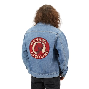 May include: Light blue denim jacket with a round red and white graphic on the back. The graphic features a profile of a Native American man and the words "Mohawk Gasoline".