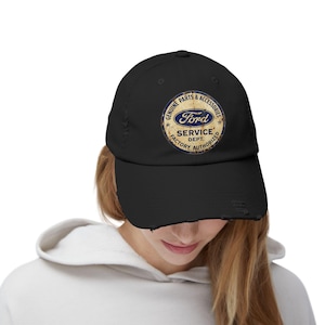 May include: Black distressed baseball cap with a circular Ford logo. The logo includes the text "GENUINE PARTS & ACCESSORIES" and "SERVICE DEPT. FACTORY AUTHORIZED". The logo is in blue, white, and gold.