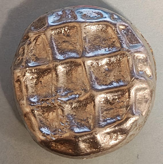 A sculptor hand-poured actual .900 coin silver into the shape of a peanut butter cookie — absurd, delightful, and genuinely one-of-a-kind metal art.