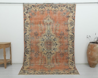 Puede incluir: Una alfombra rectangular grande con un campo naranja prominente, un medallón central y patrones florales intrincados en tonos azul, crema y marrón oscuro. La alfombra tiene un borde decorativo ancho con motivos.