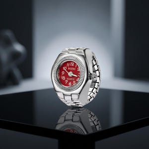 May include: A silver ring watch with a red face. The watch face has white numerals and hands, with the brand name "BOZHI" printed at the top. The band is made of linked silver metal.