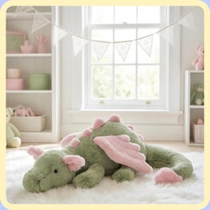 May include: A plush green dragon toy with pink accents, including wings, ear tips, and dorsal spines, lies on a white fluffy rug. The dragon is in a child's bedroom, with a window and shelves in the background.