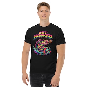 May include: Black t-shirt with a colorful graphic of a fish jumping out of water, with the text "GET HOOKED" in rainbow colors. The fish and water are in vibrant shades of blue, green, yellow, and red.