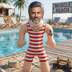 Könnte beinhalten: Eine aufblasbare Puppe mit dem Gesicht eines Mannes, die einen rot-weiß gestreiften Badeanzug und ein Anker-Tattoo trägt. Ein Tiegel Sonnencreme, eine Sonnenbrille und eine Hantel befinden sich in der Nähe. Das Schild im Hintergrund lautet "Muscle Beach".