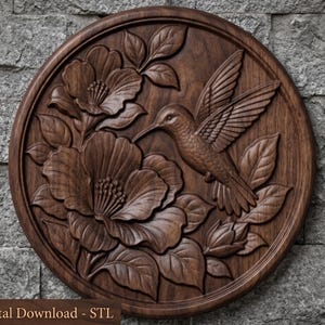 May include: A circular dark brown wood carving featuring a hummingbird in flight approaching two large blooming flowers with detailed petals and leaves. The piece includes the text Digital Download - STL at the bottom of the frame.