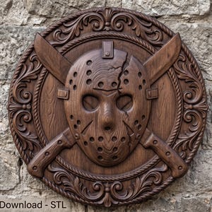 May include: A circular dark brown wooden wall plaque featuring a carved hockey mask with a crack, positioned over two crossed machetes. The border is decorated with intricate scrollwork and rope detailing. The text Digital Download - STL is visible.