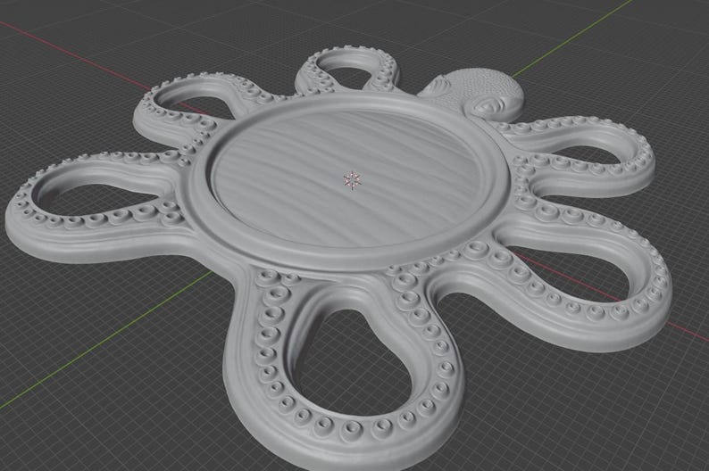 May include: A light gray, circular tray featuring a central flat surface surrounded by eight radiating octopus tentacles. Each tentacle is detailed with a series of small, raised circular suction cups along the inner edge of the arm.