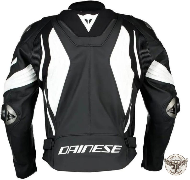 May include: Black and white motorcycle jacket with the brand name "DAINESE" printed across the lower back. The jacket features white accents on the shoulders and sides, with protective padding on the elbows. The back of the jacket is visible.