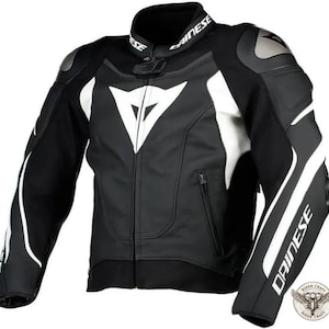 May include: Black and white motorcycle jacket with the brand name "DAINESE" on the collar and sleeve. The jacket features white accents on the shoulders, sleeves, and chest, with a large white logo on the chest. The jacket has a zipper closure and protective padding.