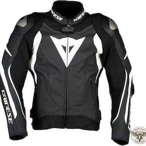 May include: Black and white motorcycle jacket with the brand name "Dainese" on the collar and sleeves. The jacket features white accents and a large white logo on the chest. Includes shoulder and elbow protection.