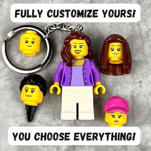 Puede incluir: Un llavero personalizable con una minifigura de plástico de pelo castaño, cárdigan morado y pantalones blancos. Incluye tres cabezas intercambiables adicionales con diferentes peinados, incluida una gorra rosa, y el texto FULLY CUSTOMIZE YOURS! YOU CHOOSE EVERYTHING!