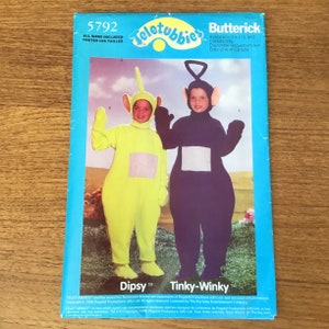 May include: A blue Butterick pattern envelope featuring Teletubbies costumes. The costumes are Dipsy in lime green and Tinky-Winky in dark purple. The envelope includes the text "5792" and "All Sizes Included".