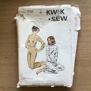 Op de afbeelding: Een vintage Kwik Sew naaipatroon envelop. De omslag toont illustraties van twee vrouwen in pyjama's. Het patroonnummer is 1056 en de maten zijn S-M-L. De envelop is licht versleten, met het Kwik Sew-logo zichtbaar.